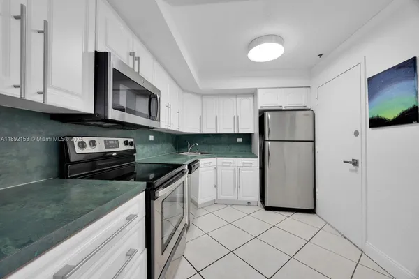 a kitchen with granite countertop a refrigerator and a sink