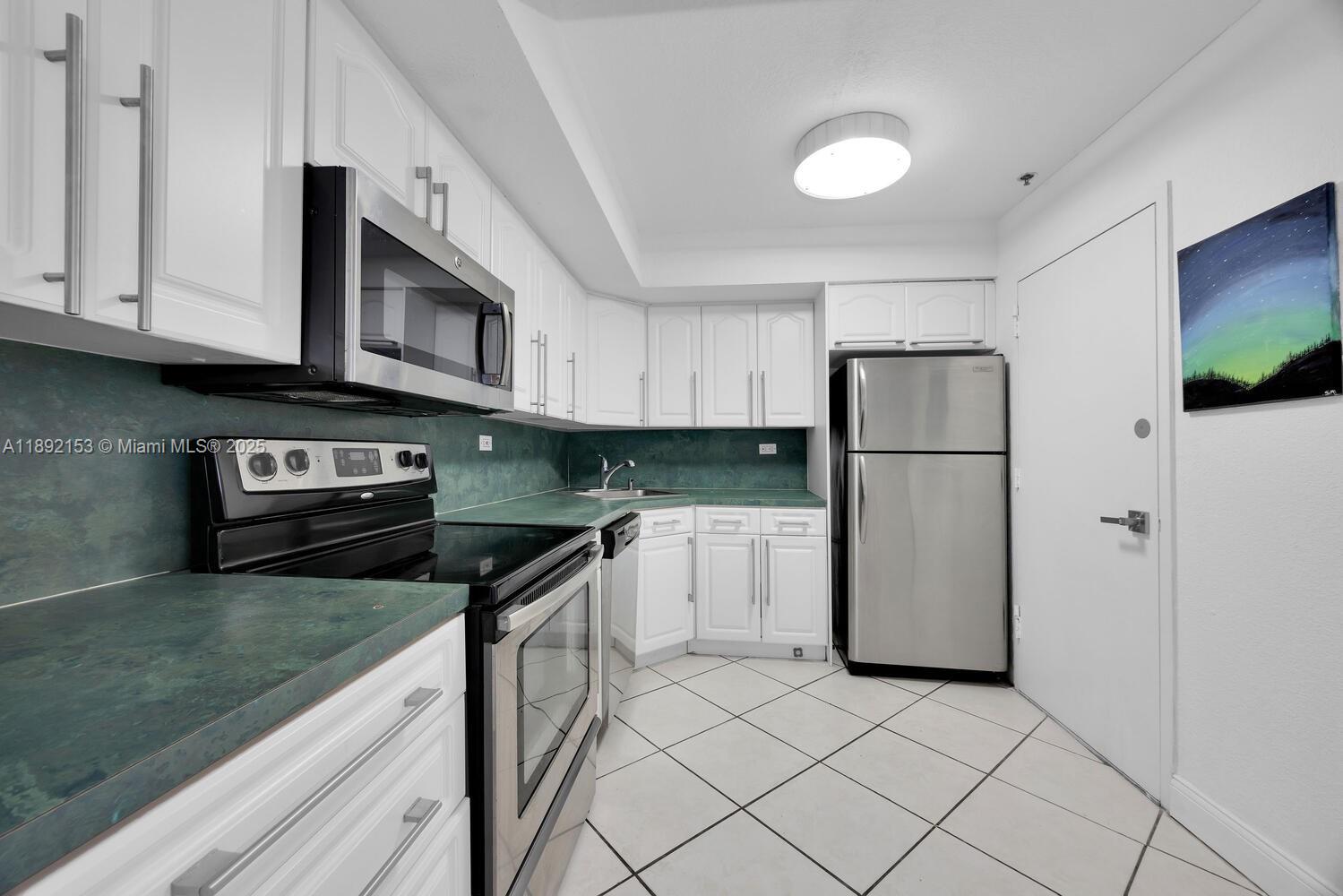 6039 Collins Avenue, Unit 311 Miami Beach, FL 33140 - Photo 13 of 26 a kitchen with granite countertop a refrigerator and a sink