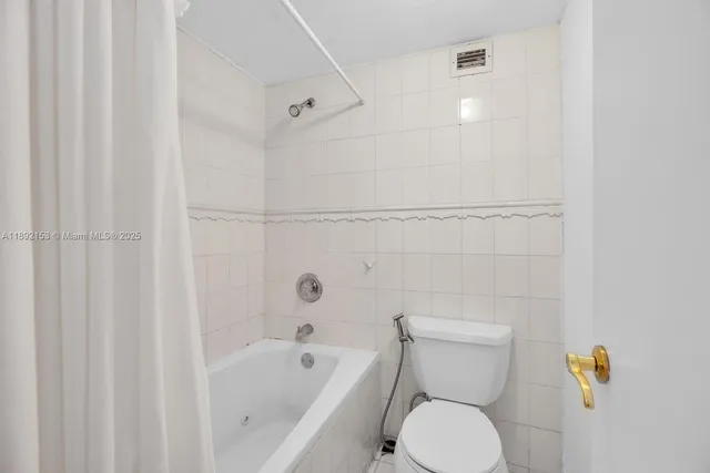a white toilet sitting next to a bath tub