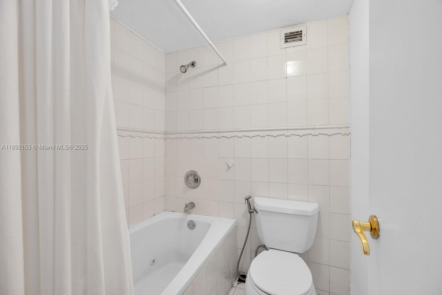 6039 Collins Avenue, Unit 311 Miami Beach, FL 33140 - Photo 16 of 26 a white toilet sitting next to a bath tub