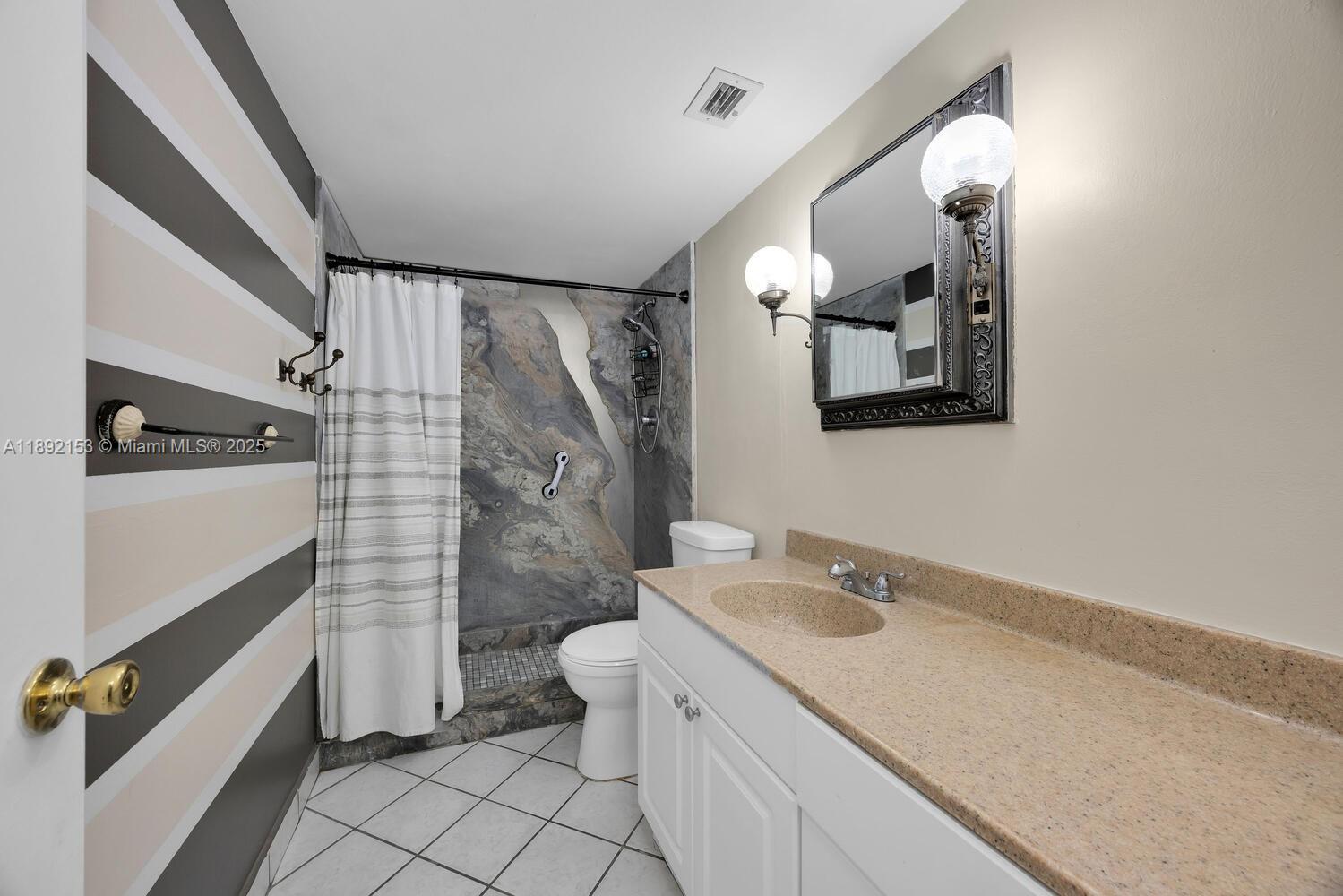 6039 Collins Avenue, Unit 311 Miami Beach, FL 33140 - Photo 18 of 26 a bathroom with a sink a toilet and shower
