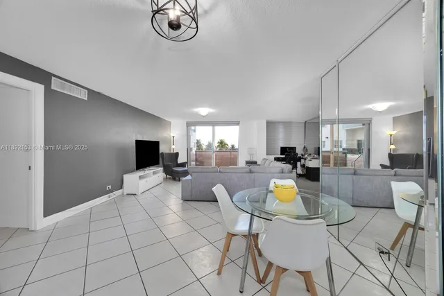 a living room with furniture a rug and kitchen view
