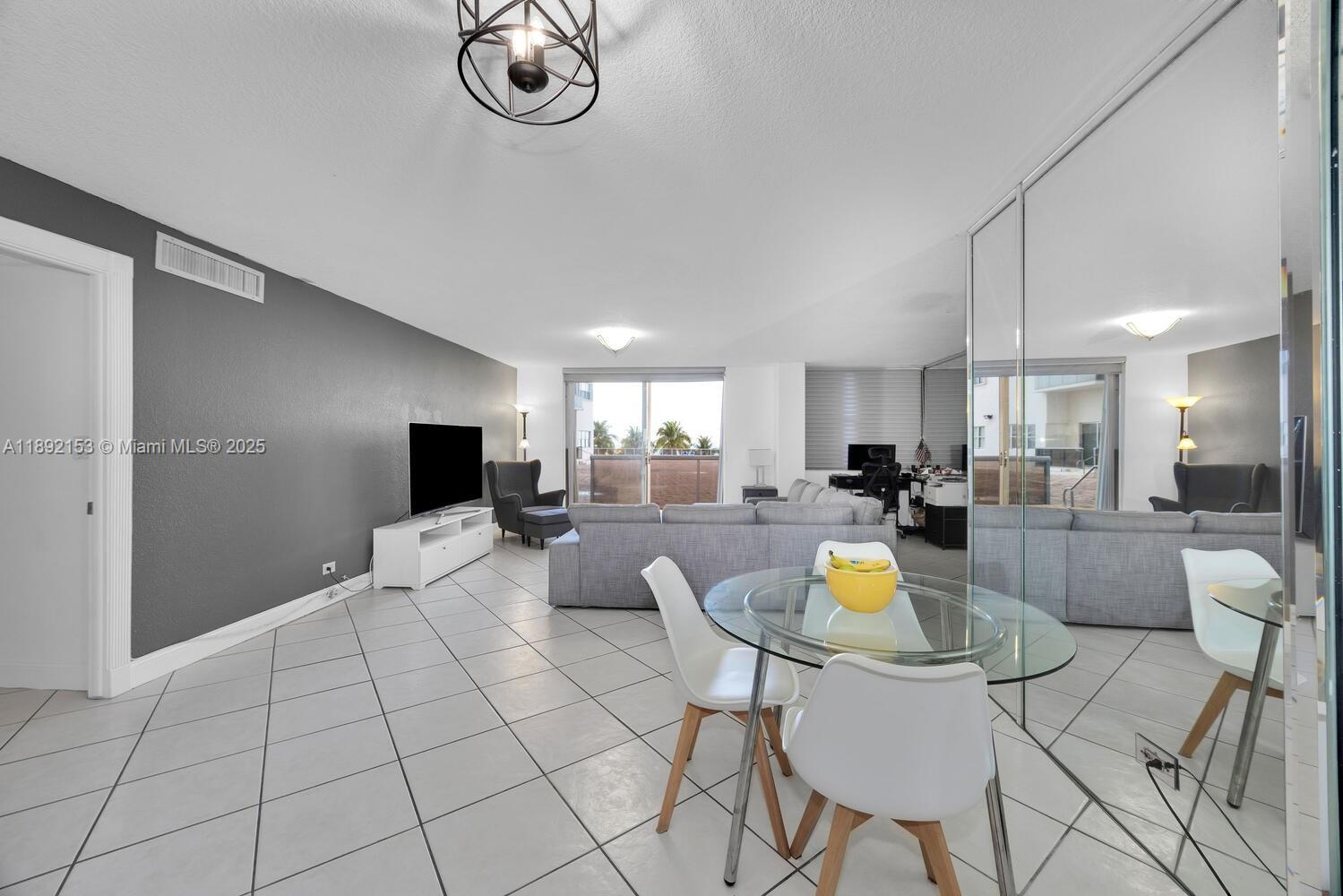 6039 Collins Avenue, Unit 311 Miami Beach, FL 33140 - Photo 9 of 26 a living room with furniture a rug and kitchen view