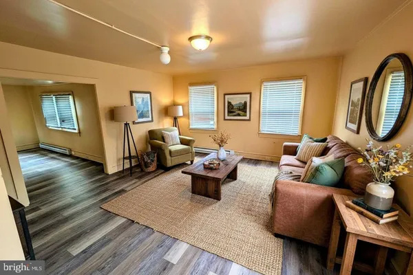 a living room with furniture and a wooden floor