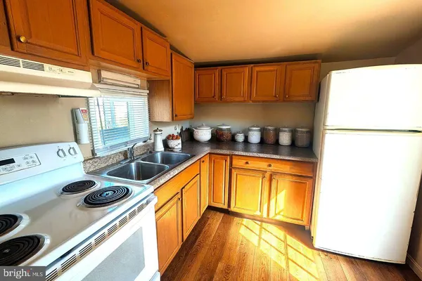 a kitchen with a sink a stove and a refrigerator