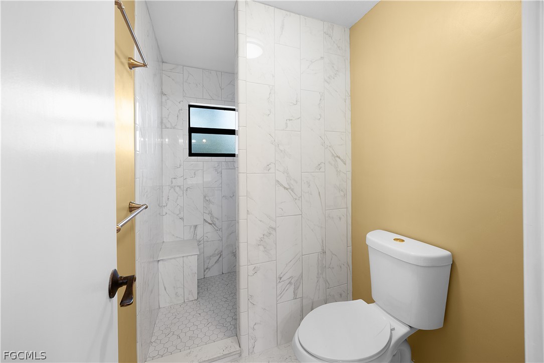 13520 Island Road Fort Myers, FL 33905 - Photo 14 of 36 a white toilet sitting next to a shower curtain