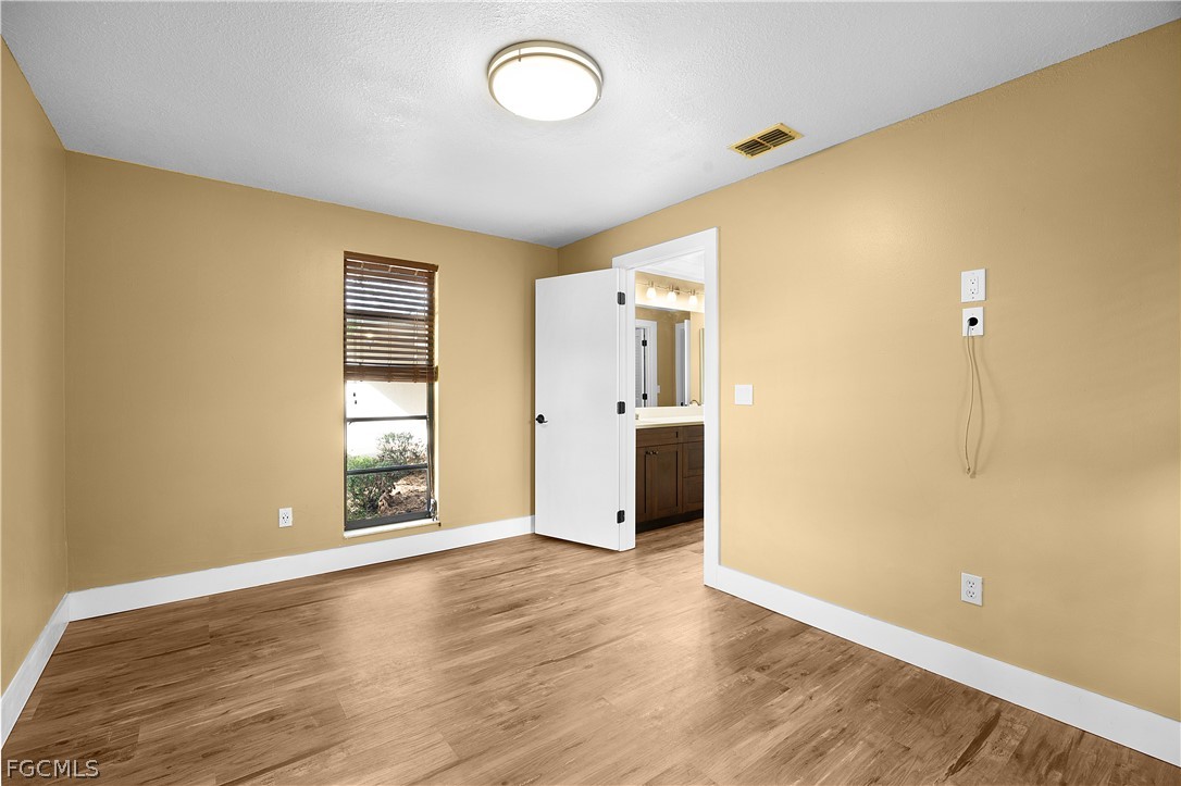 13520 Island Road Fort Myers, FL 33905 - Photo 17 of 36 an empty room with wooden floor and windows