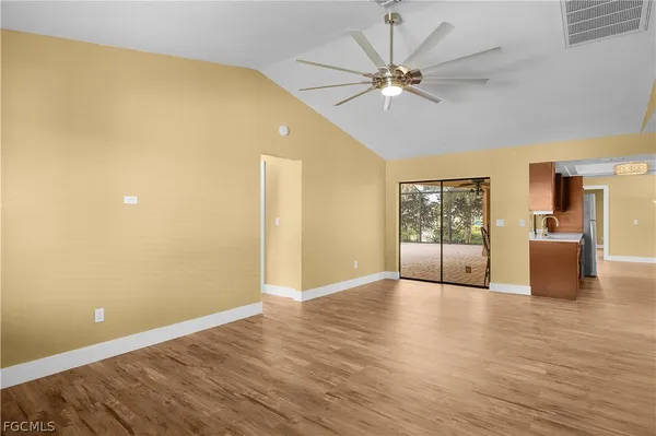 a view of a big room with wooden floor and windows