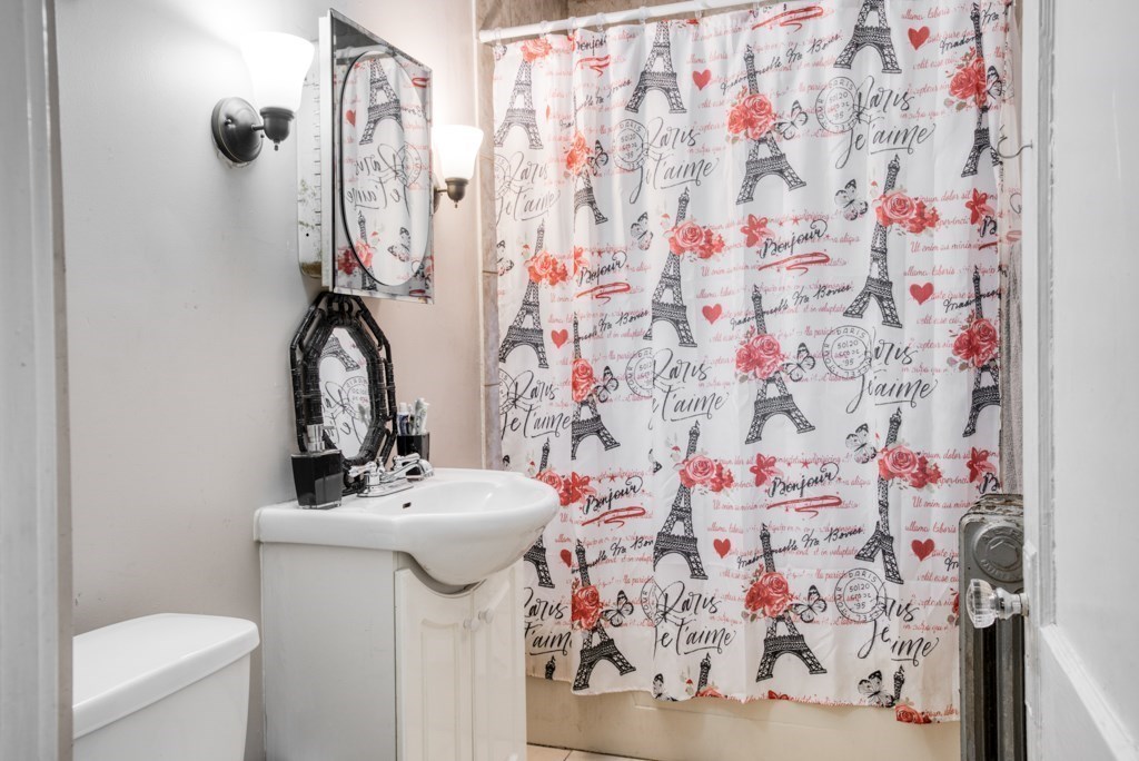 70-72 Windemere Street Springfield, MA 01104 - Photo 16 of 42 a bathroom with a sink toilet and shower curtain