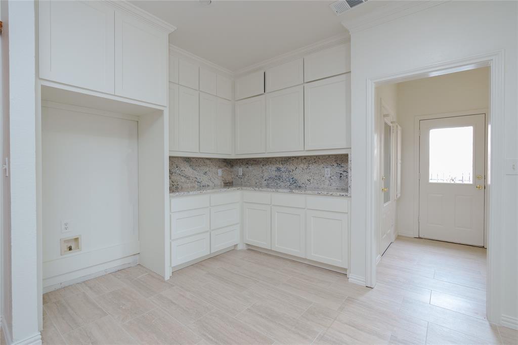 364 Parker Road, Unit A Van Alstyne, TX 75495 - Photo 13 of 39 Kitchen area featuring extensive white shaker cabinetry, speckled countertops, a matching backsplash, and light wood-finish flooring
