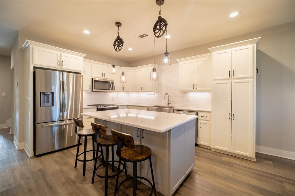 4721 Dry Creek Road Sherman, TX 75092 - Photo 2 of 25 a kitchen with a refrigerator a sink and chairs
