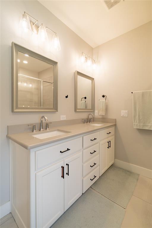 4721 Dry Creek Road Sherman, TX 75092 - Photo 10 of 25 a bathroom with double sink and a mirror