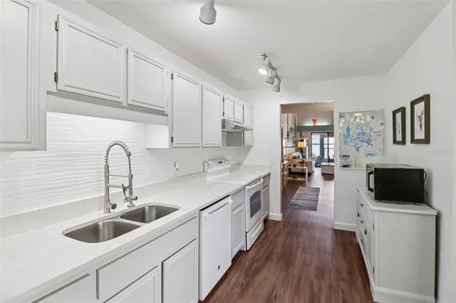 a kitchen with sink a refrigerator and cabinets