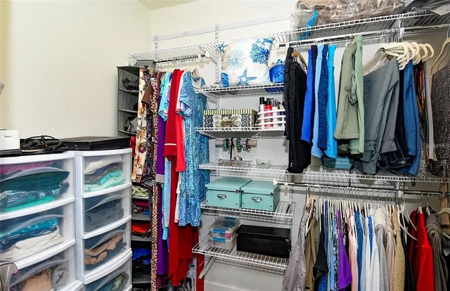 a view of walk in closet with clothes and shoes