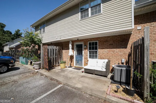a view of a house with a patio and wooden fence