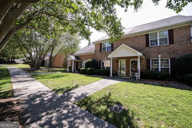 a front view of a house with yard and green space