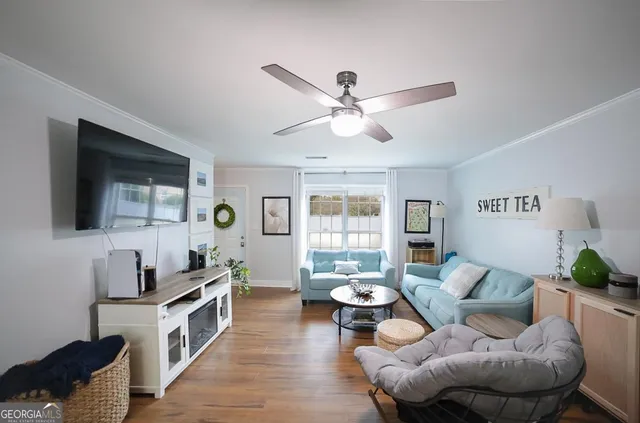 a living room with furniture kitchen view and a window