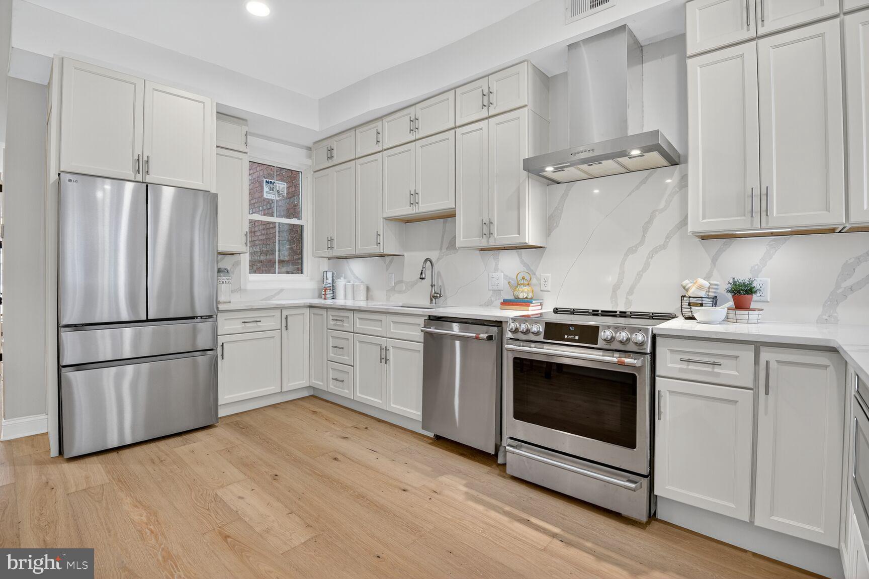316 U Street Northwest Washington, DC 20001 - Photo 8 of 37 a kitchen with cabinets stainless steel appliances and wooden floor