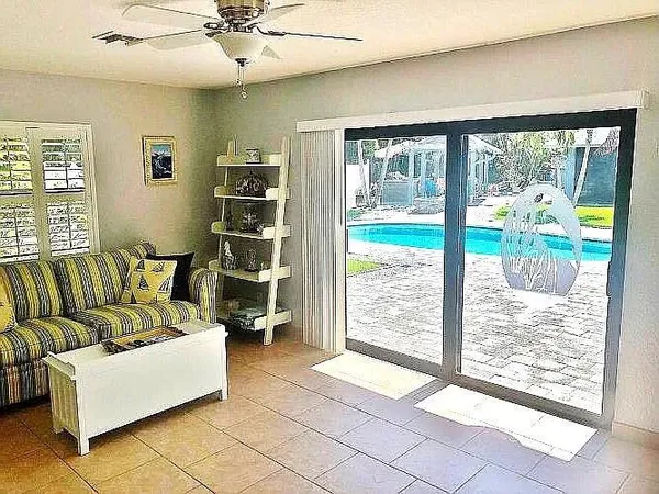 a kitchen with stainless steel appliances kitchen island granite countertop a dining table chairs and a refrigerator