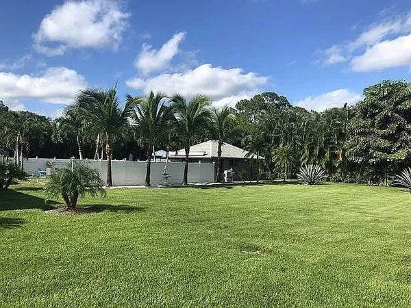 a patio with a table and chairs and potted plants