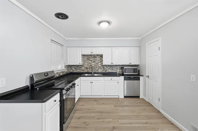 a kitchen with a sink a stove and cabinets