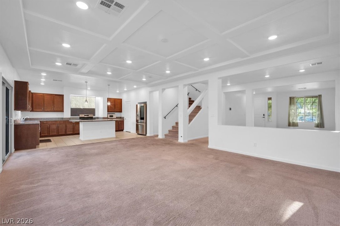 8046 Noble Ridge Street Las Vegas, NV 89139 - Photo 7 of 34 An inviting open-concept layout connects the well-appointed kitchen with the spacious living area, highlighted by coffered ceilings.