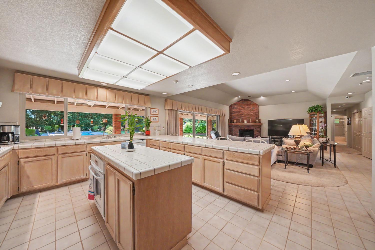 9069 Bader Road Elk Grove, CA 95624 - Photo 13 of 70 Kitchen featuring tile flooring, light wood-finish cabinetry, tile countertops, and a central island with an integrated oven