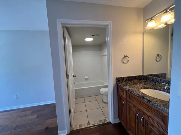 a bathroom with a granite countertop sink a mirror and shower