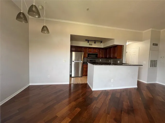 a view of a kitchen with a white cabinets and wooden floor