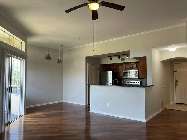 a view of an empty room with a window and wooden floor