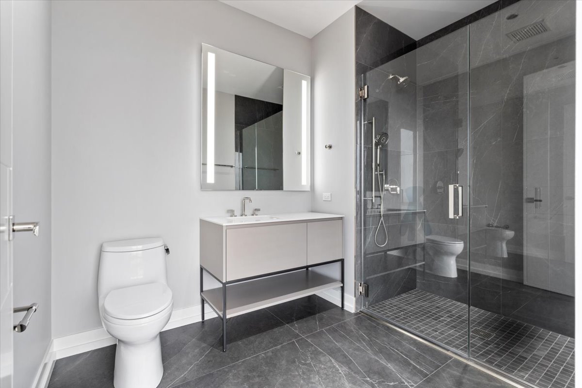 14 West Superior Street, Unit 6002 Chicago, IL 60654 - Photo 28 of 44 a bathroom with a toilet sink and shower