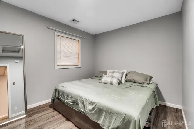 a bedroom with a bed and wooden floor