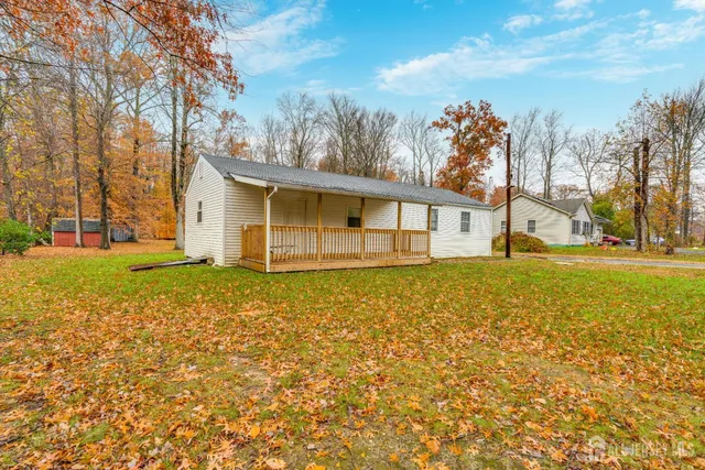 a view of a house with backyard and trees