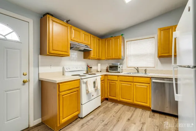 a kitchen with stainless steel appliances granite countertop wooden cabinets a sink and a window
