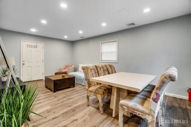 a living room with furniture a flat screen tv and a wooden floor