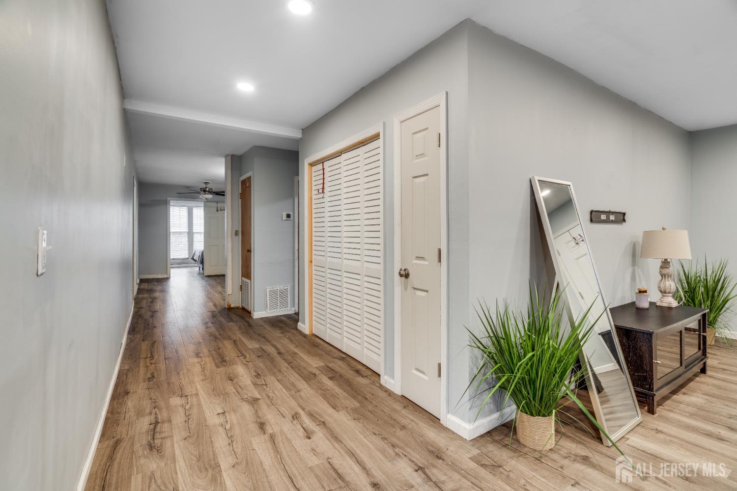 113 Fresh Ponds Road Monroe Township, NJ 08831 - Photo 10 of 18 a view of a hallway with wooden floor and stairs