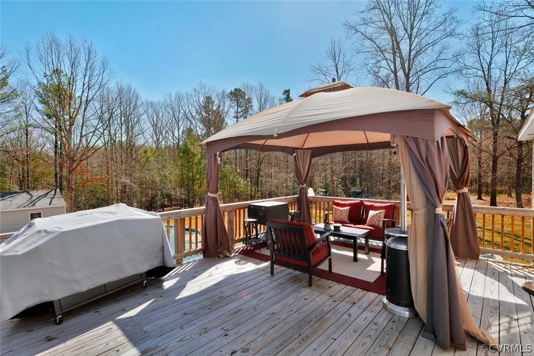 21003 Skinquarter Road Moseley, VA 23120 - Photo 17 of 22 a patio of a house with table and chairs under an umbrella with wooden floor