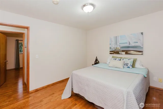 a bedroom with a bed and wooden floor