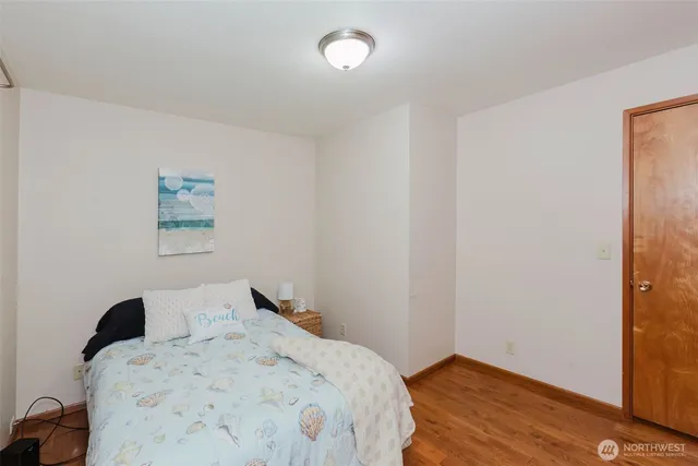 a bedroom with a bed and wooden floor