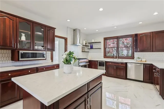 a kitchen with stainless steel appliances a microwave sink stove refrigerator and cabinets