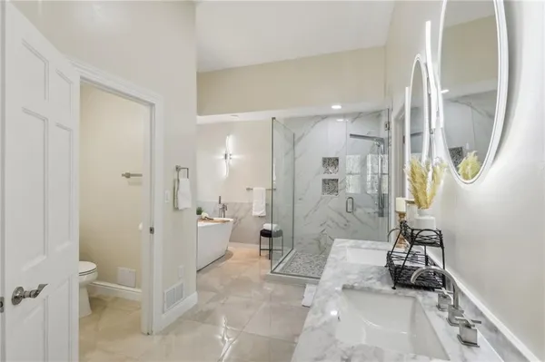 a bathroom with a glass shower door a sink and a mirror