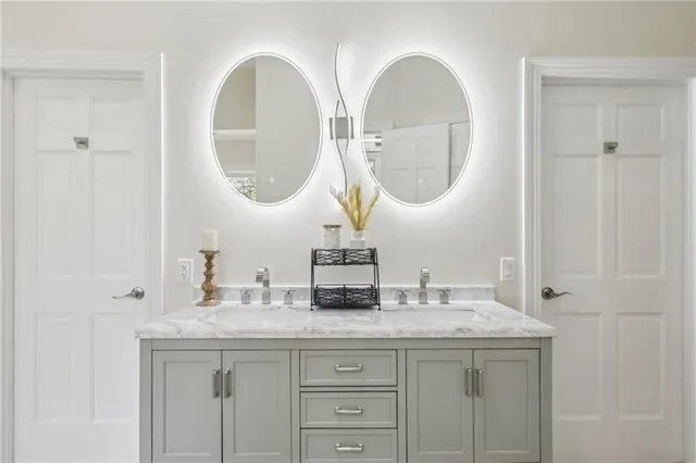 a bathroom with a granite countertop double vanity sinks and a mirror