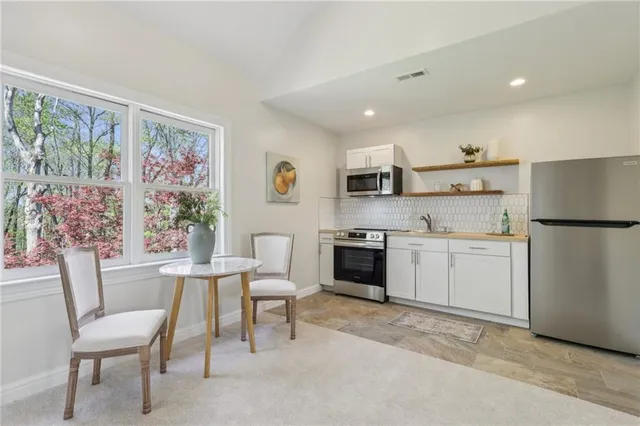 a kitchen with a refrigerator and white cabinets
