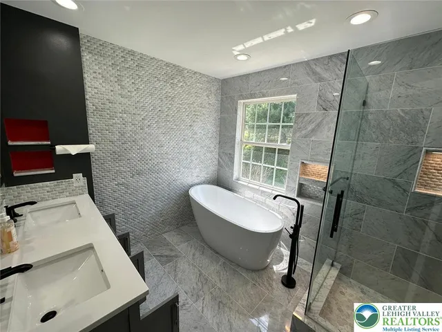 an empty room with wooden floor a ceiling fan and windows