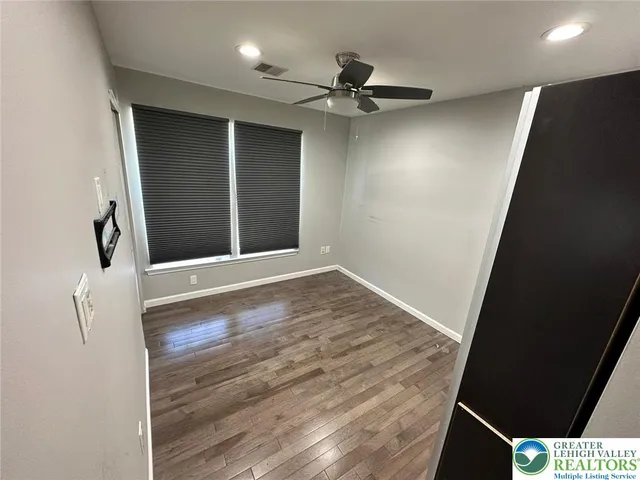 a view of a livingroom with wooden floor and a ceiling fan