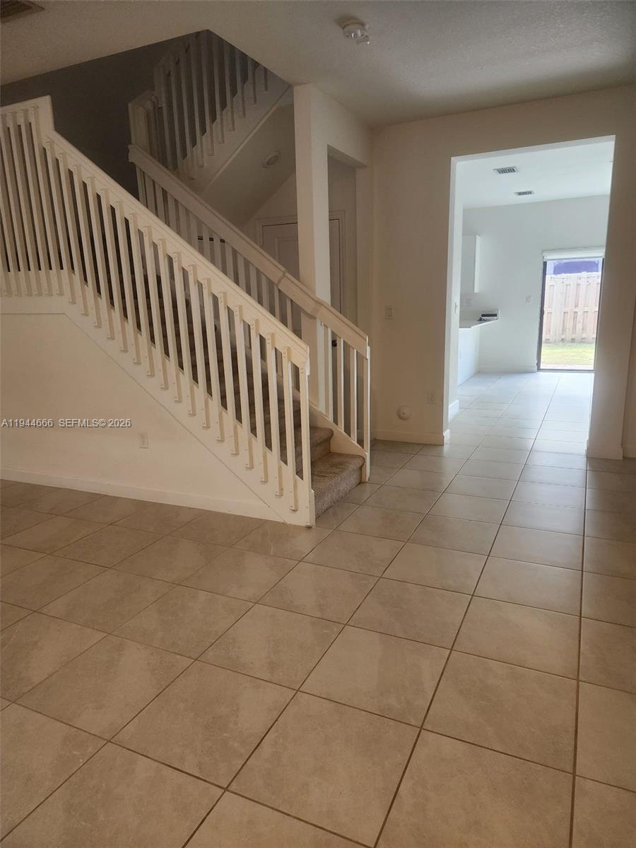 12946 Southwest 232nd Terrace, Unit 12946 Homestead, FL 33032 - Photo 2 of 11 a view of staircase with white walls and stairs