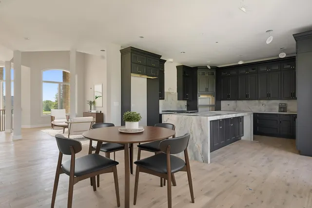 a kitchen with a table chairs sink and cabinets