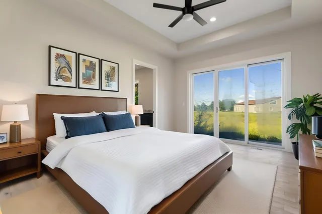 a bedroom with a large bed and a potted plant