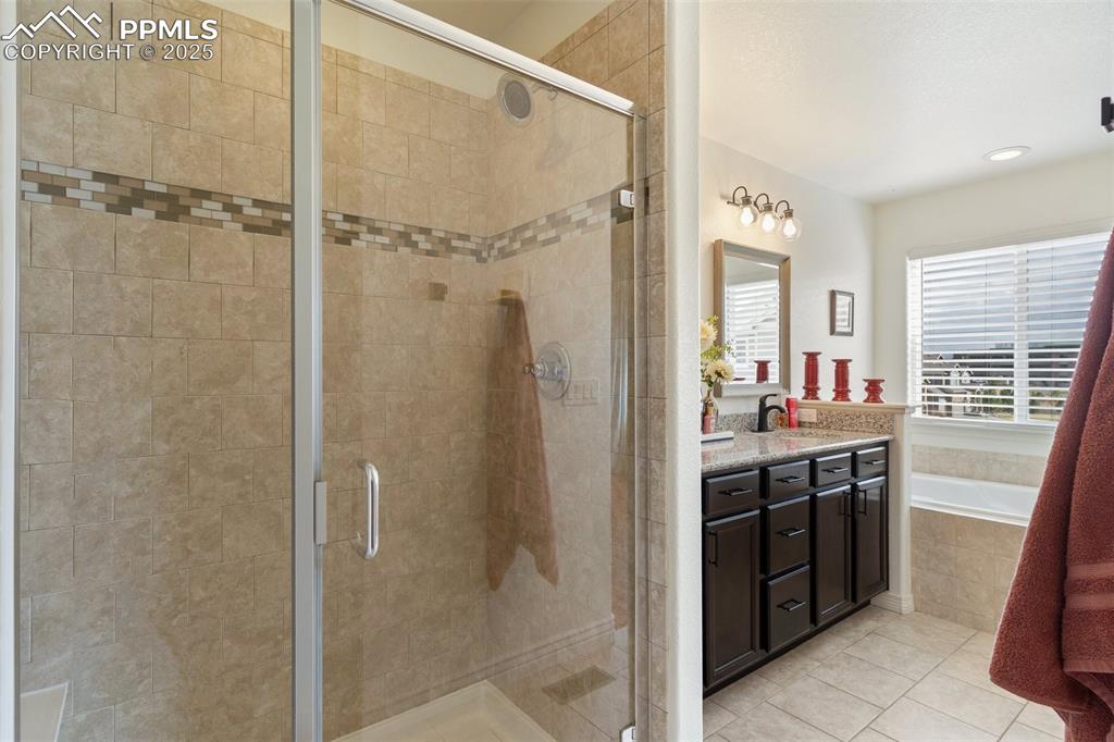 977 Salmon Pond Way Colorado Springs, CO 80921 - Photo 17 of 49 a bathroom with a granite countertop shower sink and mirror