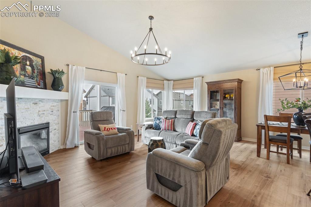 977 Salmon Pond Way Colorado Springs, CO 80921 - Photo 22 of 49 a living room with couches a fireplace and kitchen view with wooden floor